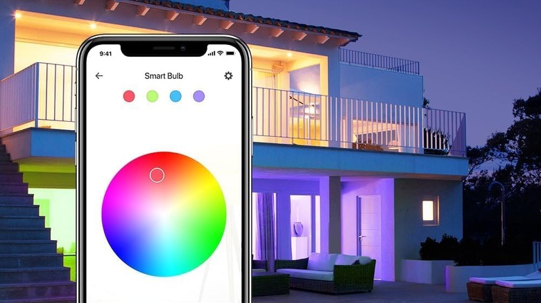A phone with a color wheel in front of a house with lights being different.