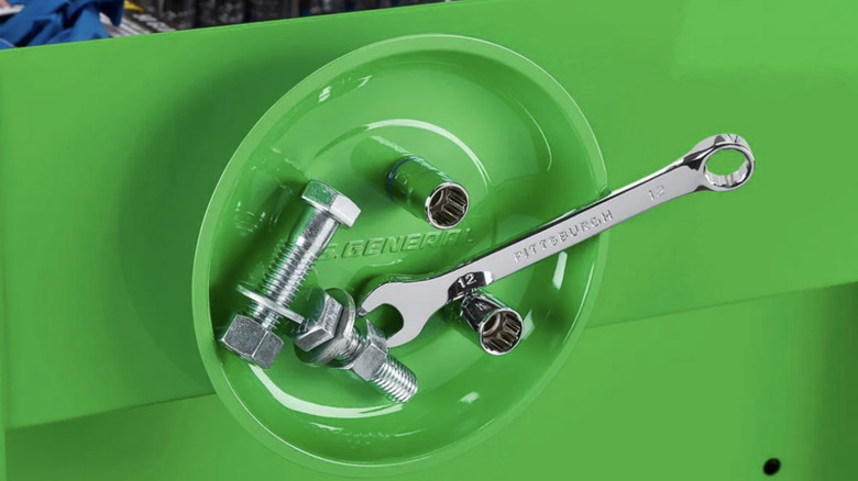 Harbor Freight magnetic parts holder in green holding a wrench and other metal items