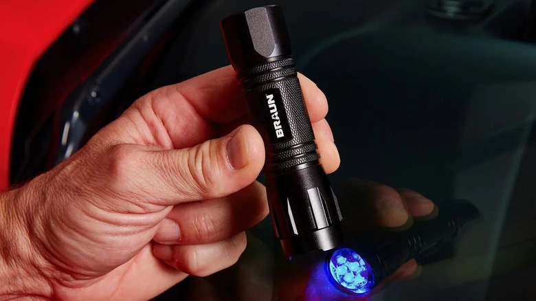 Hand powers on the Braun UV Leak Detector LED Flashlight