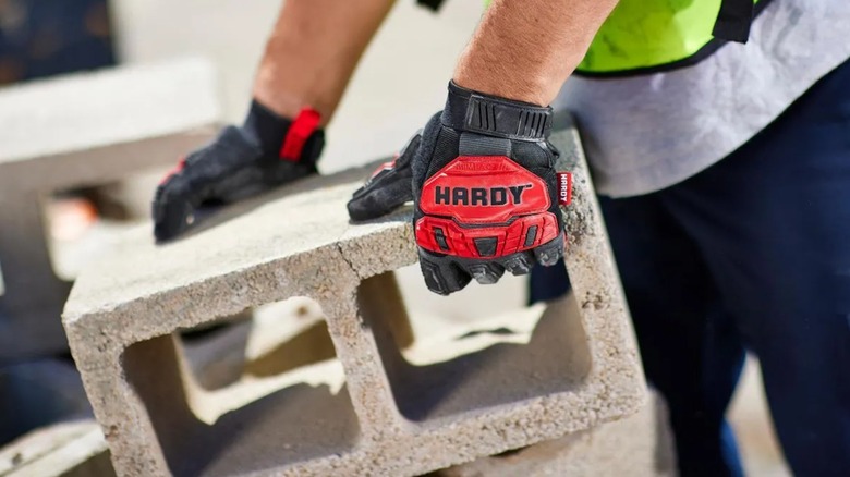 A person wearing a pair of Hardy impact-resistant work gloves from Harbor Freight.