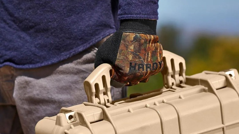 A person wearing Hardy camouflage work gloves from Harbor Freight.