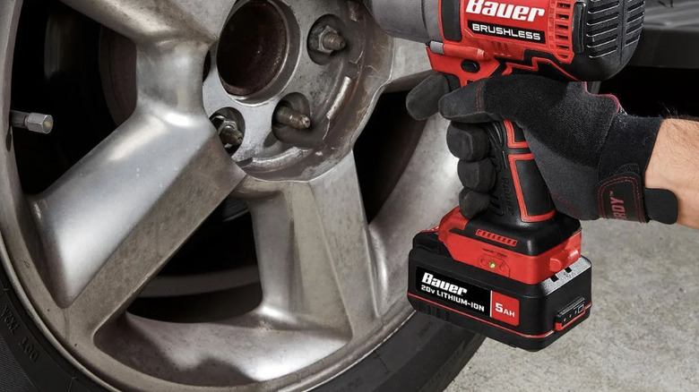 Mechanic using a Bauer brushless wrench with Bauer 20V 5 ah battery