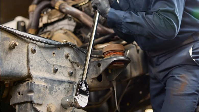 Person using a Harbor Freight Icon G2 long ratchet on a car chassis bolt