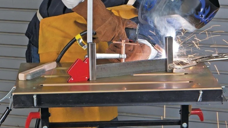 A person working on a Chicago Electric welding table from Harbor Freight.