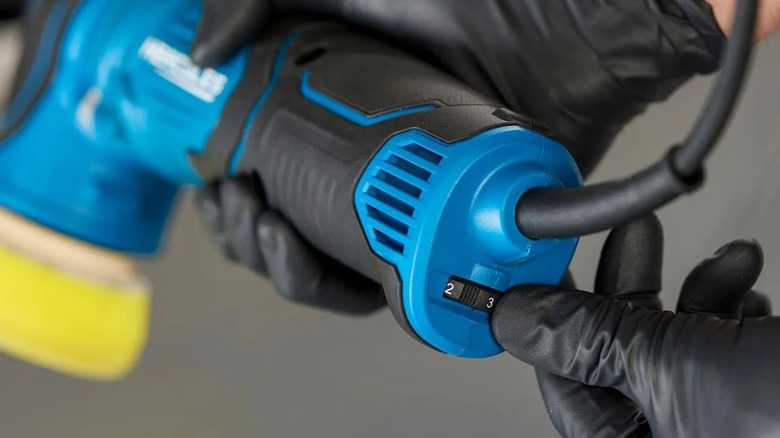 A person changing a Hercules polisher's speed.