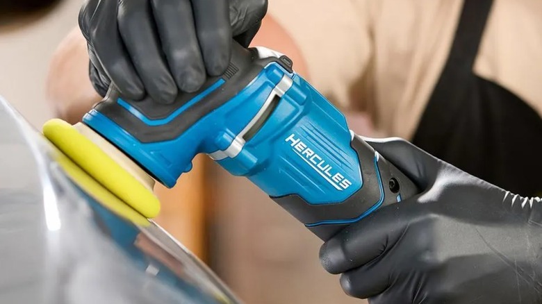 A person using a Hercules polisher on a car.