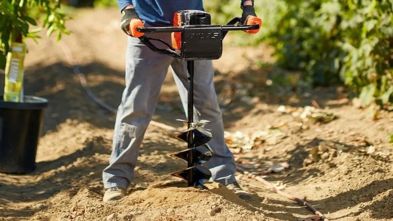 Person using Harbor Freight Atlas 80V Auger in field