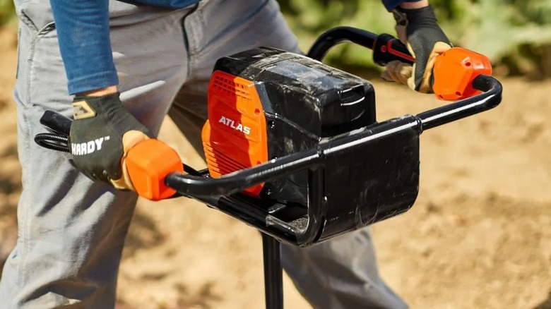 Close-up of a person using Harbor Freight Atlas 80V Auger