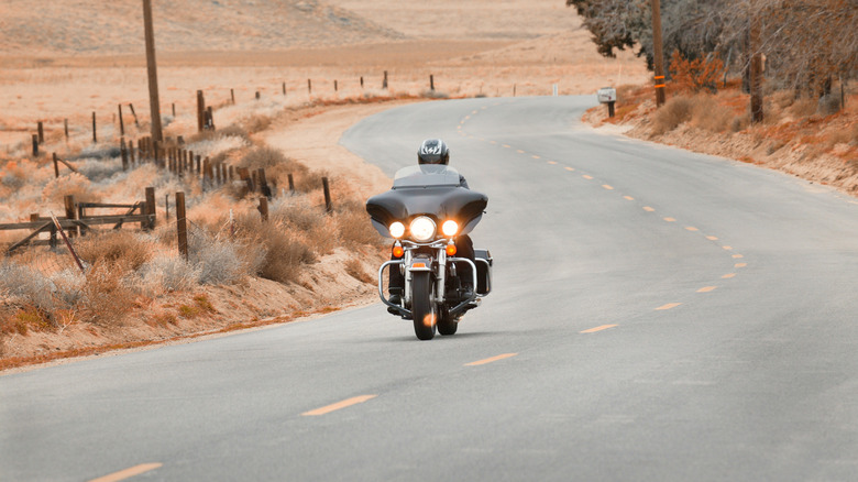Motorcycle rider on a Harley Davidson rounds a corner
