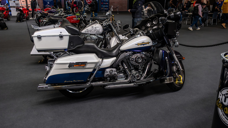 A white and black Harley-Davidson Electra Glide Ultra Limited motorcycle parked indoors at auto show