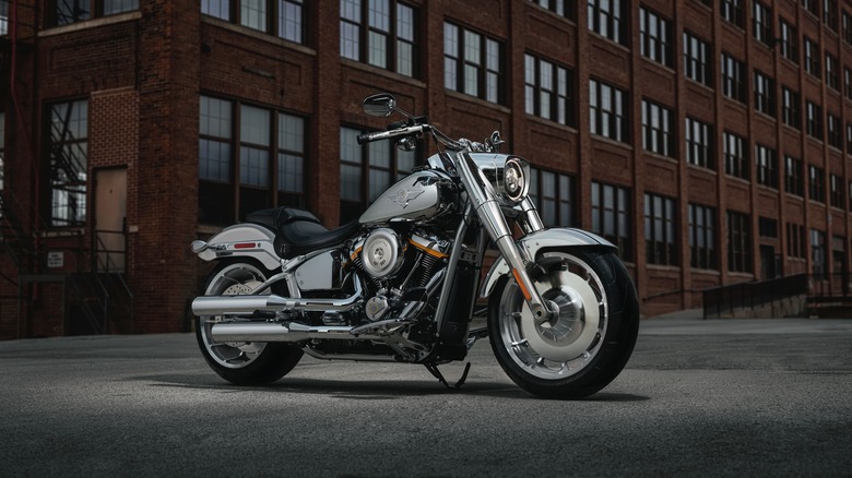 Front 3/4 view of a silver 2025 Harley-Davidson Grey Ghost in front of a warehouse