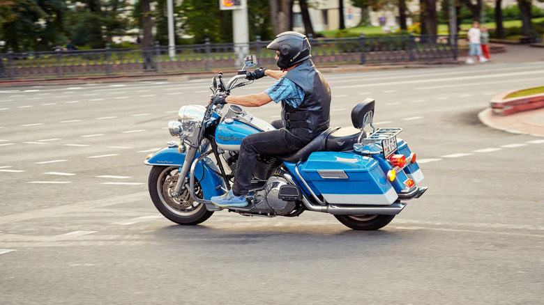 A light blue Harley Davidson Road king in motion on a road