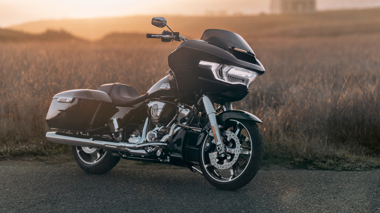 A black Harley Davidson Road Glide at sunrise, front 3/4 view