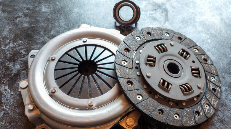 Clutch pressure plate, diaphragm, and throwout bearing arranged on gray surface