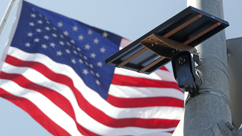 Low-angle shot of a Flock camera with an American flag in the background