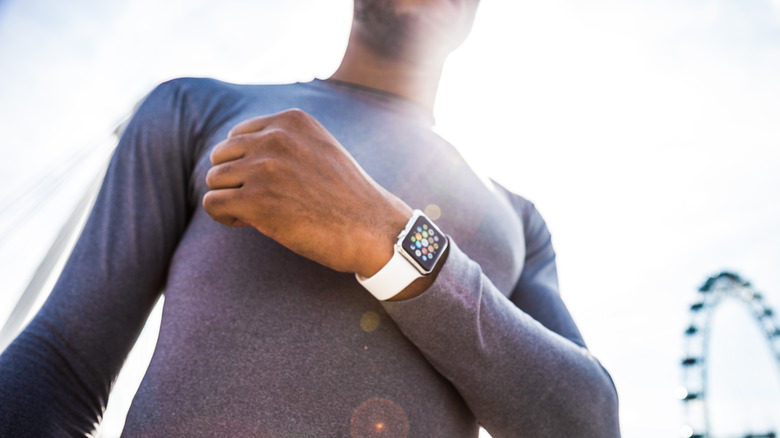 A jogger displays his Apple Watch in front of chest