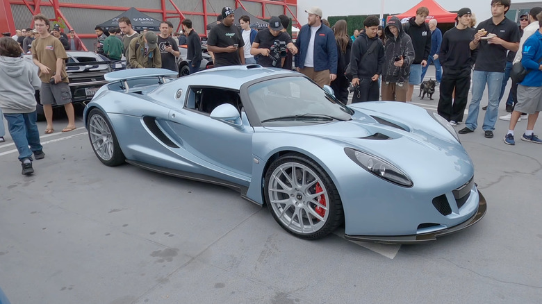 A front 3/4 view of a silver-blue Hennessey Venom GT with silver wheels at a car show