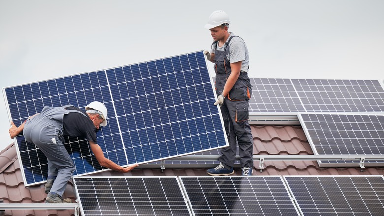 People installing solar panels on roof