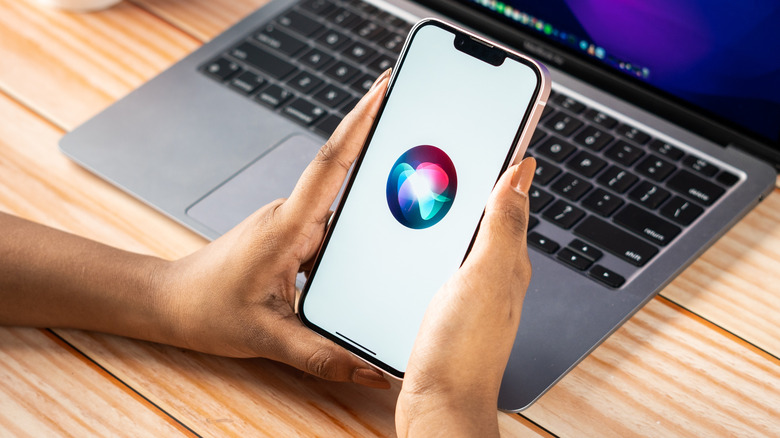 woman holding iPhone with Siri logo displayed