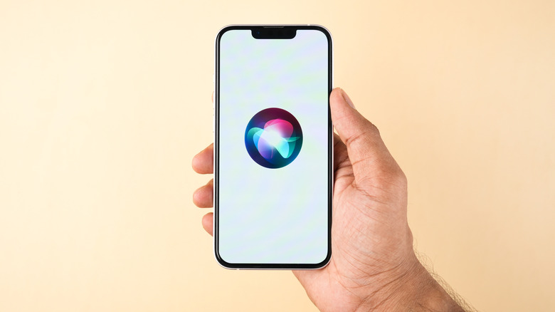 hand holding iPhone showing Siri logo