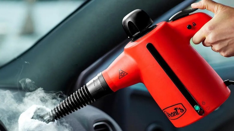 Peson using Grant's Handheld Steam Cleaner in a car