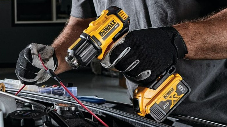 A person using a DeWalt heat gun.