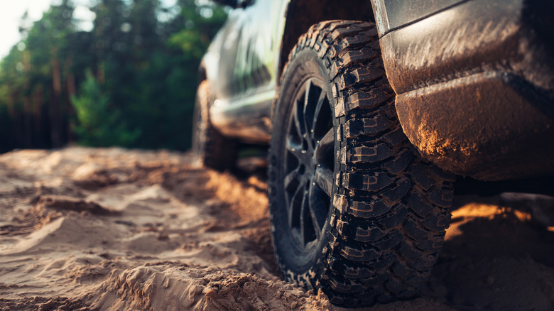 Close-up of an all-terrain tire covered in mud