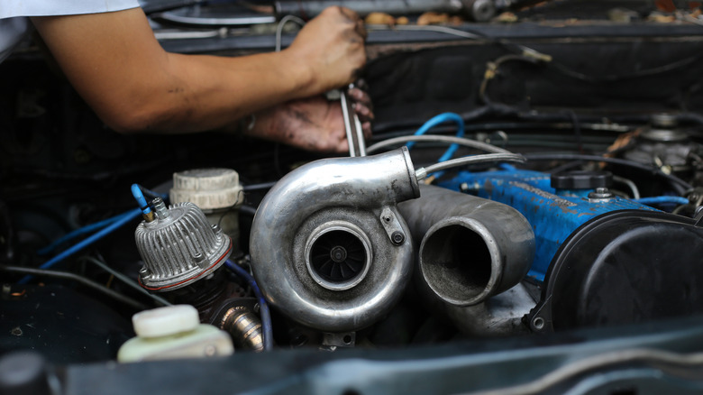 Man working on car engine and turbocharger