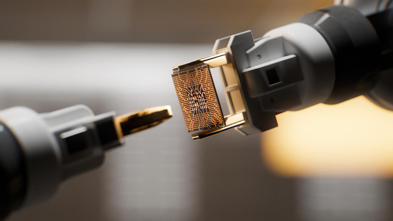 A copper colored microchip being manufactured by robotic arms. The chip is in the middle facing a blurry robot arm.