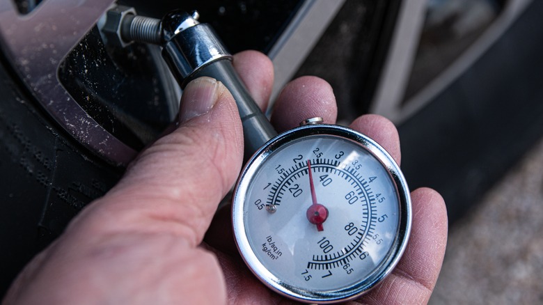 Close shot of tire pressure gauge checking tire pressure