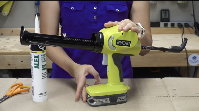 woman holding Ryobi caulking gun