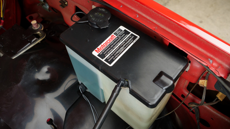 The windshield wiper fluid reservoir in the engine bay of a Ford vehicle.