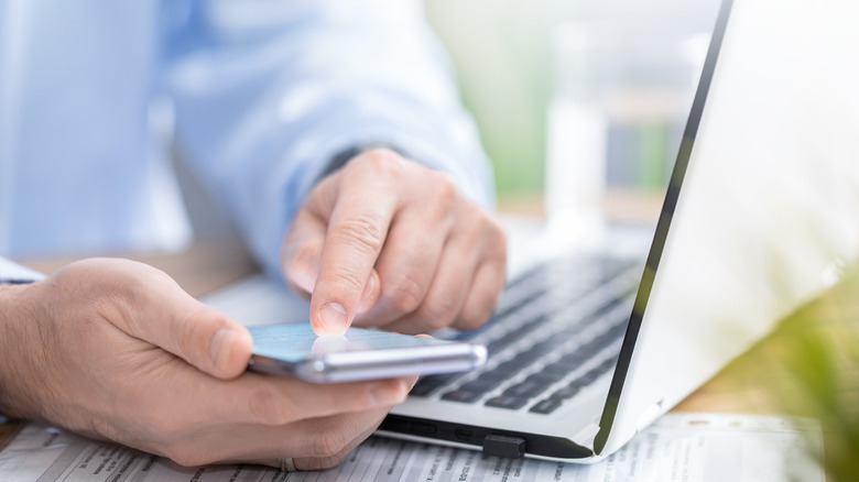 man using laptop and smartphone