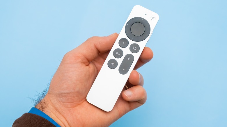 Holding Apple TV watch on blue background