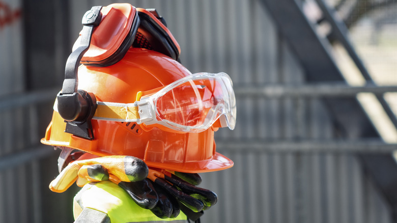 PPE items, like helmet, gloves, and ear protection, stacked on top of each other.