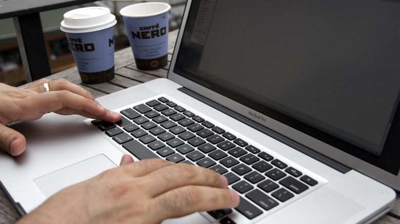 Man tapping keys on MacBook