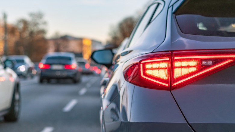 Close-up of the left rear brake light on a navy SUV in traffic