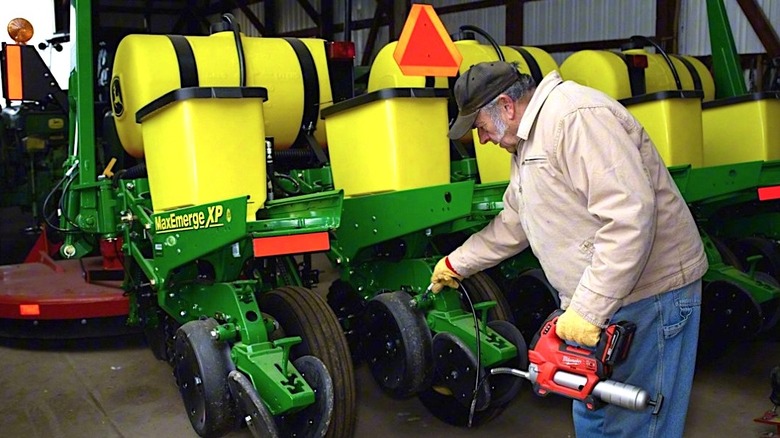 Person using cordless Milwaukee grease gun