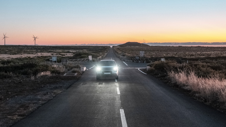 car on the highway with high beams on