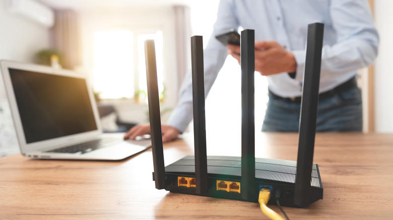 Wi-Fi router on a table with computer and man in background