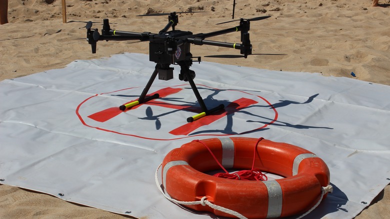 A rescue drone on the ground next to a life buoy.