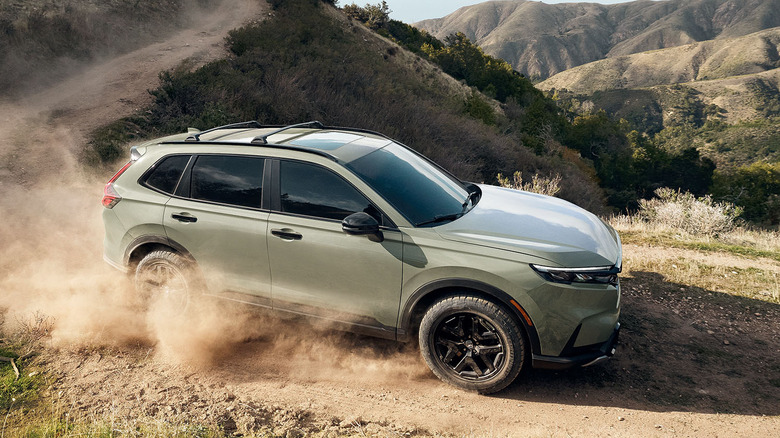 The 2026 Honda CR-V TrailSport on the move on a sandy track, front 3/4 view