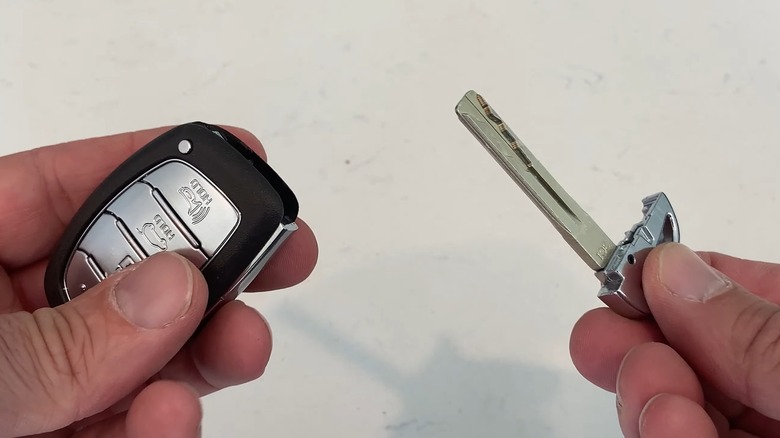 A man removing the hidden physical key from a key fob