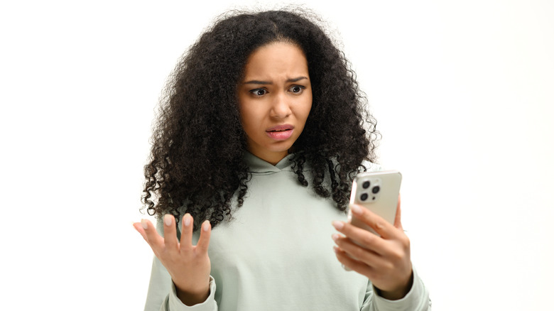 exasperated person frowning smartphone