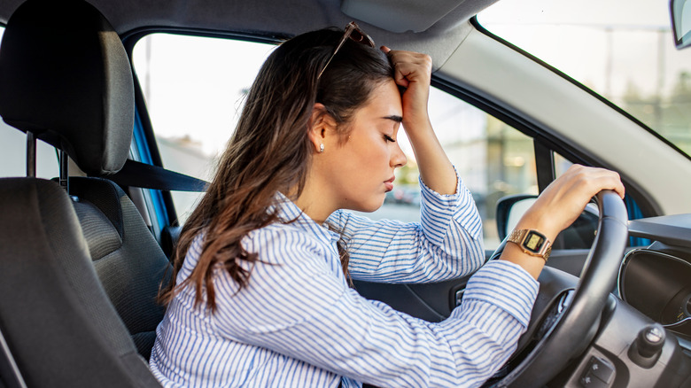 woman clutching steering wheel in distress
