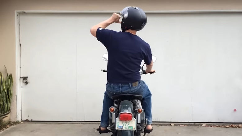 A biker performs the rest stop signal