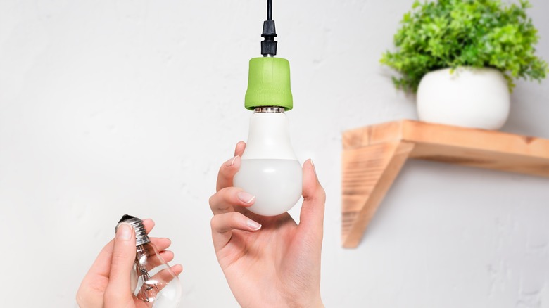 Hands changing a lightbulb 