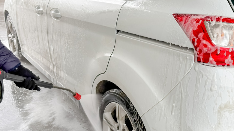 Person washing their car in winter