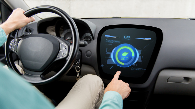 Man pressing car's eco mode button