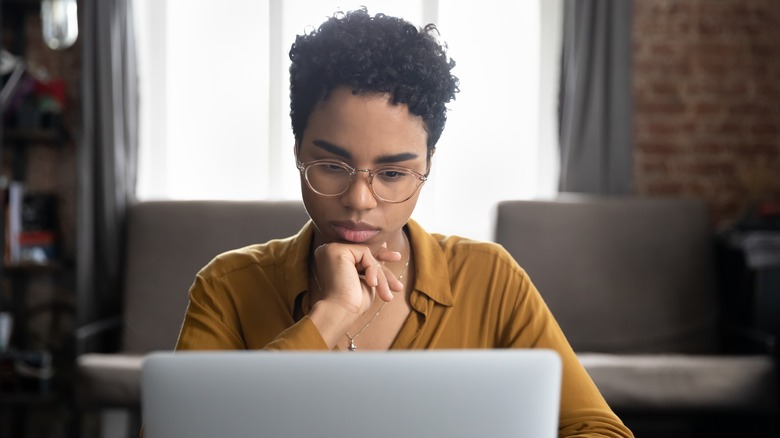 Person in glasses looking at laptop screen